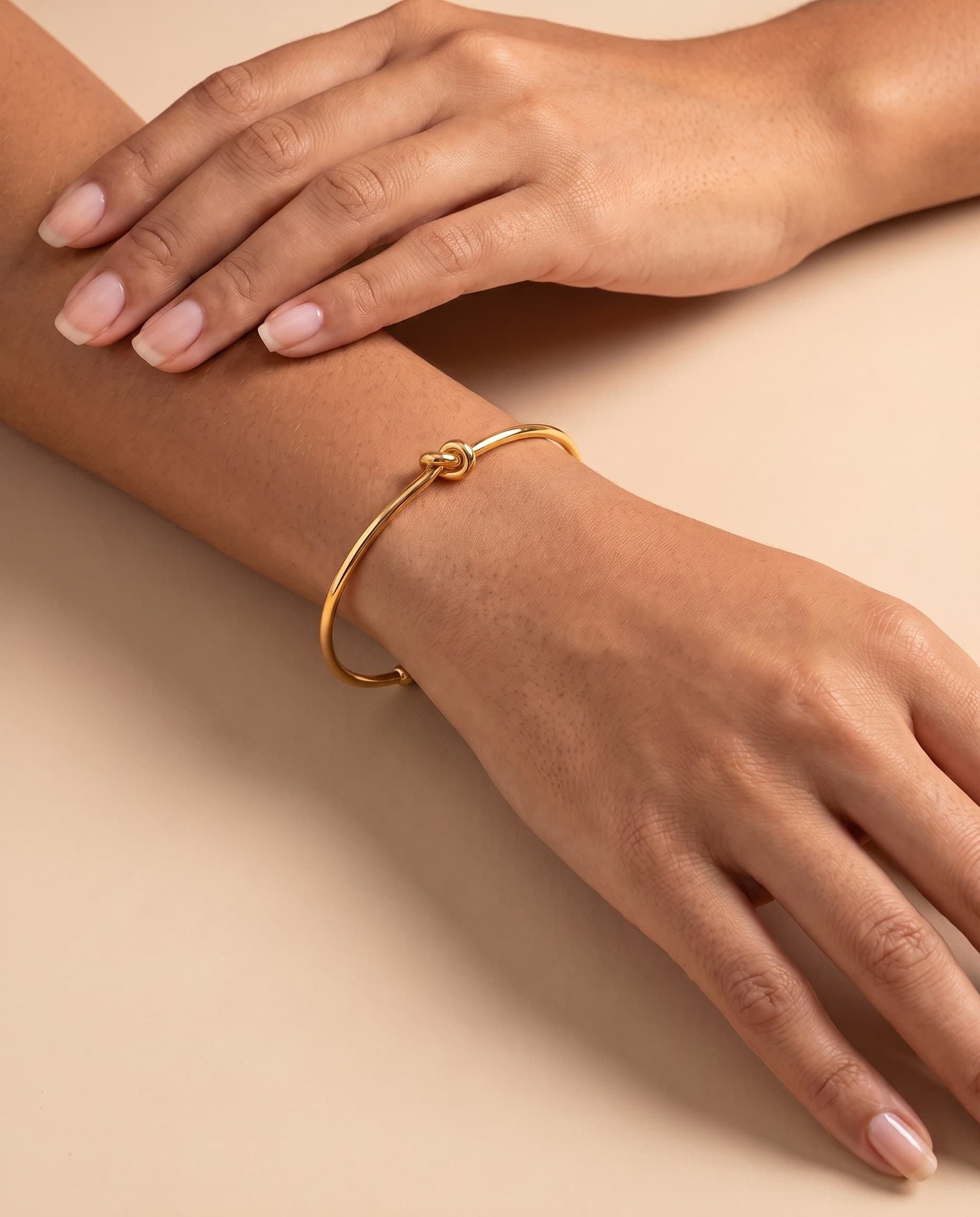 Bracelete de nó em banho de ouro no pulso da modelo